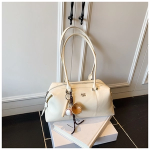 Detail of cream Boston bag featuring leather grain and baseball themed charms