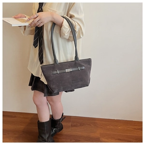 Close-up of charcoal grey suede tote bag with decorative strap and silver metal buckle