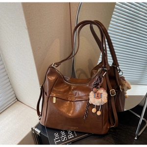 Detail of vintage brown leather tote bag showing smooth texture and logo branding