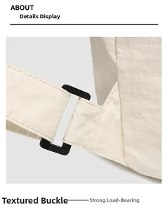 Detail of durable matte black buckle and reinforced nylon webbing on white sports backpack