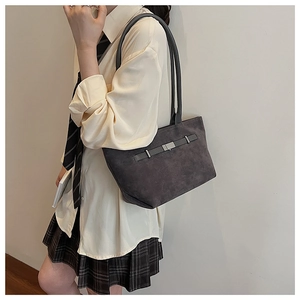 Detailed view of dark grey suede tote bag with leather strap and metal buckle