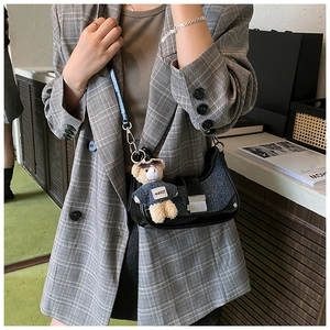 Chic shoulder bag detail with leather and denim stitching plus a cute teddy bear charm