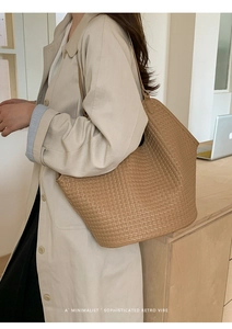 Side view of large woven tote bag in light coffee brown on a model for office use