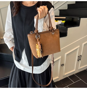 Detail of leopard print bucket bag featuring suede texture and beaded tassel decoration