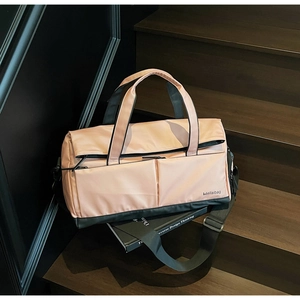 Détail du sac de sport étanche avec compartiment humide sur des marches en bois sombre