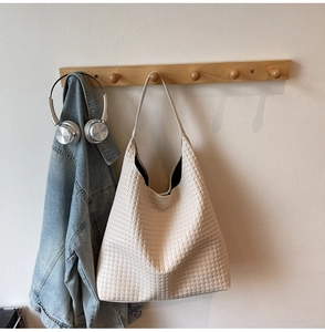 Detail of cream woven hobo shoulder bag featuring intricate textures and soft leather feel