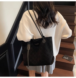 Quilted black tote bag with diamond pattern shown on shoulder for daily commute style