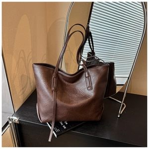 Vista dettagliata della grande borsa tote marrone vintage con eleganti tracolle lunghe
