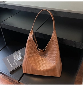 Detail of brown woven hobo bag showing intricate texture and slim shoulder strap
