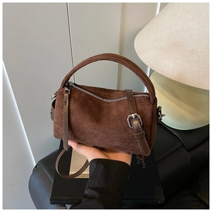 Nahaufnahme der braunen Veloursleder-Tasche mit Retro-Mattoptik und Ledergriff-Details