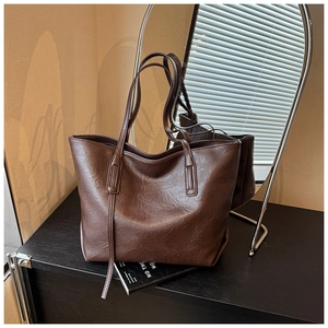 Borsa tote in pelle testurizzata marrone scuro con spalline lunghe su base nera lucida