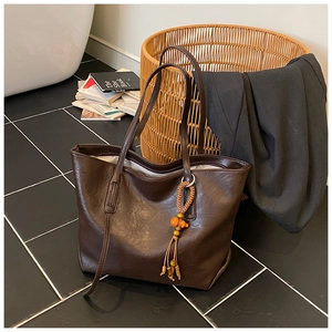 Dettaglio ravvicinato della borsa tote marrone scuro con nappa di perline colorate