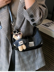 Fashionable half-moon crossbody bag in black leather and blue denim with bear charm