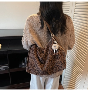 Détail du sac fourre-tout en daim léopard avec bandoulière en cuir et gri-gri
