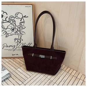 Detail of burgundy suede tote bag featuring silver metal buckle and brown leather strap