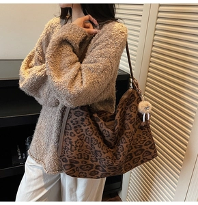Détail du sac cabas en daim léopard avec bandoulière en cuir et breloque en peluche
