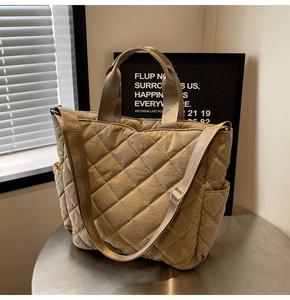 Detail of khaki quilted tote bag featuring padded diamond pattern and adjustable strap