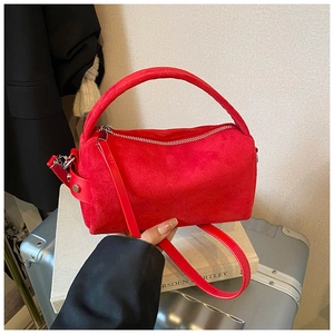 Detailansicht der roten Wildleder-Tasche mit matter Textur und silbernem Metallreißverschluss