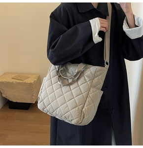 Detailed close-up of beige quilted nylon tote bag with rhombus pattern and wide strap
