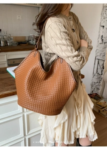 Detailed close-up of the woven brown leather texture on a large capacity tote bag