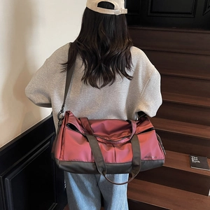 Grand sac de sport bordeaux avec séparation sec-humide sur un escalier minimaliste