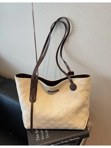 Quilted faux suede tote bag with brown leather handles in minimalist beige retro style