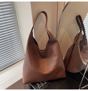 Macro detail of high-capacity dark brown woven hobo bag with vintage texture