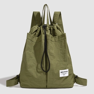 Detail of army green nylon drawstring backpack featuring a branded woven label and texture
