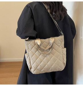 Quilted tote bag detail showing large capacity with side pockets and crossbody strap