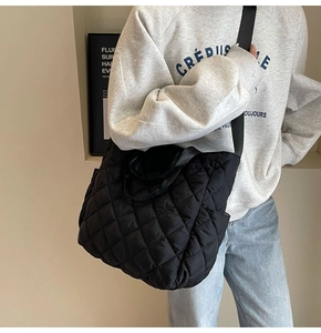 Close-up of a black quilted tote bag with large capacity for autumn and winter outfits
