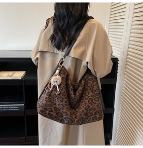 Détail du sac hobo à imprimé léopard avec pendentif en peluche et bandoulière