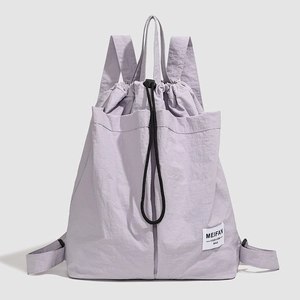 Detail of lavender drawstring backpack showing waterproof nylon fabric and brand label