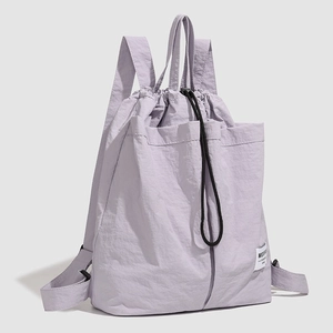 Detailed side view of lavender nylon drawstring backpack with large front utility pockets