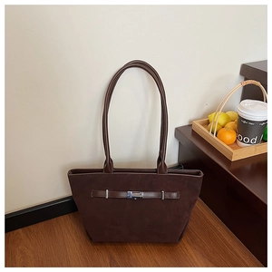 Detailed view of dark coffee suede bucket bag with silver buckle and leather strap