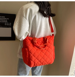 Detail of orange quilted tote bag with lattice pattern and practical side pockets