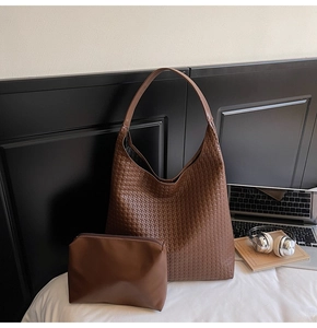 Detail of dark brown woven hobo bag and matching zip pouch with professional accessories