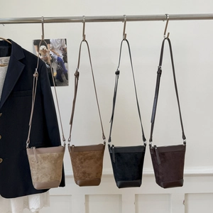 Detailed view of four suede bucket bags in beige, brown, black, and dark coffee tones