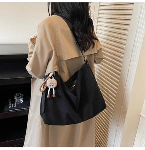 Sac hobo noir en daim avec fermeture éclair et pendentif monstre sur mannequin
