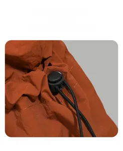 Detail of water-resistant backpack showing drawstring closure and black cord lock