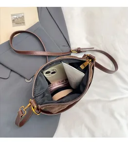 Vue intérieure d'un sac seau marron montrant l'espace pour téléphone et maquillage