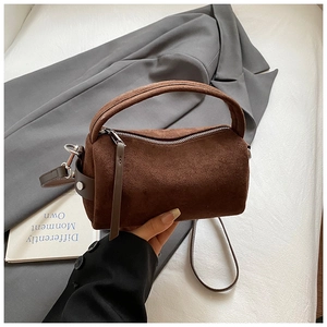 Details der braunen Zylindertasche aus Wildleder mit silbernen Beschlägen und Gurt