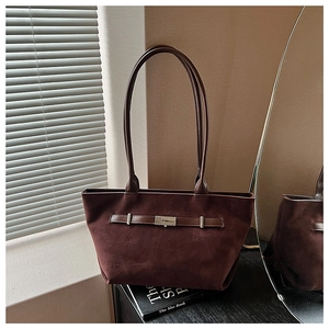Detailed view of dark brown suede tote bag featuring a silver metal buckle and strap