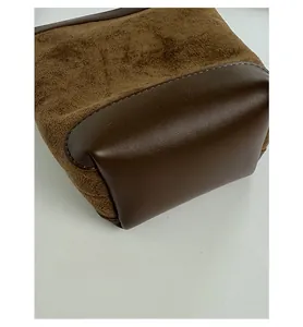 Close-up of the wide base design showing premium leather stitching on a bucket bag