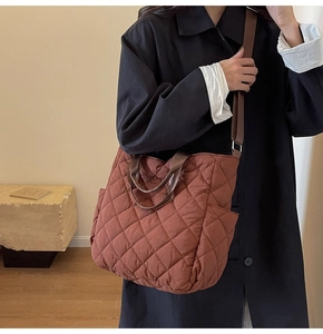 Close-up of quilted tote bag featuring a convenient side pocket and adjustable shoulder strap