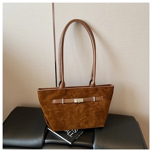 Detail of brown suede tote bag featuring silver metal buckle and slim shoulder straps