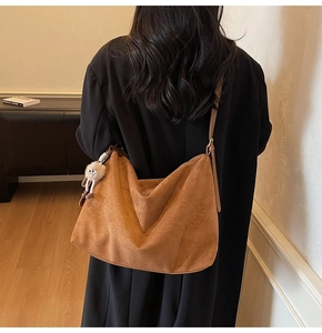 Sac hobo en daim marron orné d'une jolie breloque en peluche sur la bandoulière