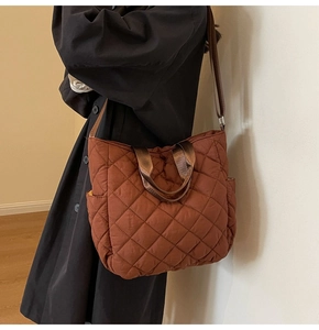 Detailed view of caramel brown quilted tote bag with rhombus pattern and side pocket