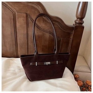 Detailed close-up of dark chocolate suede tote bag with a silver metal buckle accent