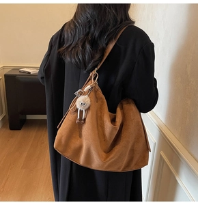 Sac fourre-tout en daim marron avec pendentif monstre en décor intérieur chaleureux