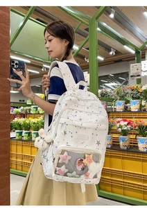 Detail of white star print backpack featuring transparent pocket and plush bunny charm